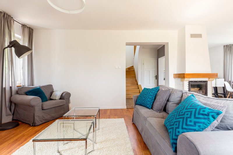 sala con muebles en tonos grises y un sillón en gris Oxford, con una mesa de vidrio sobre un tapete