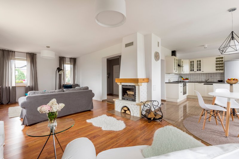 Espaciosa sala con pareces blancas y piso de madera